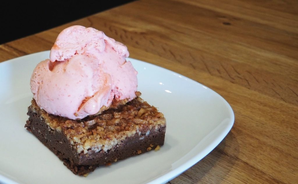 The coconut brownie, Escape to Coconut Island, served with strawberry gelato.